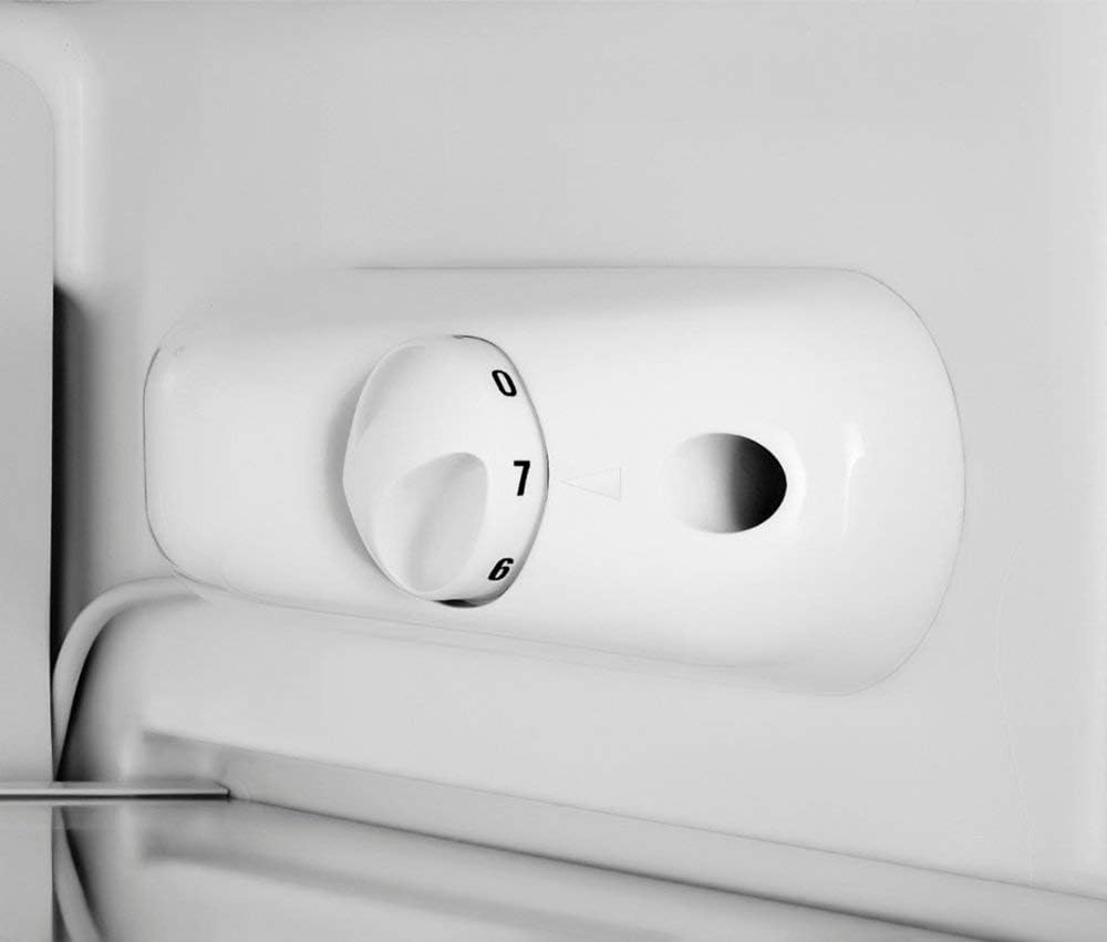 Close-up of a white refrigerator control panel with a temperature dial.