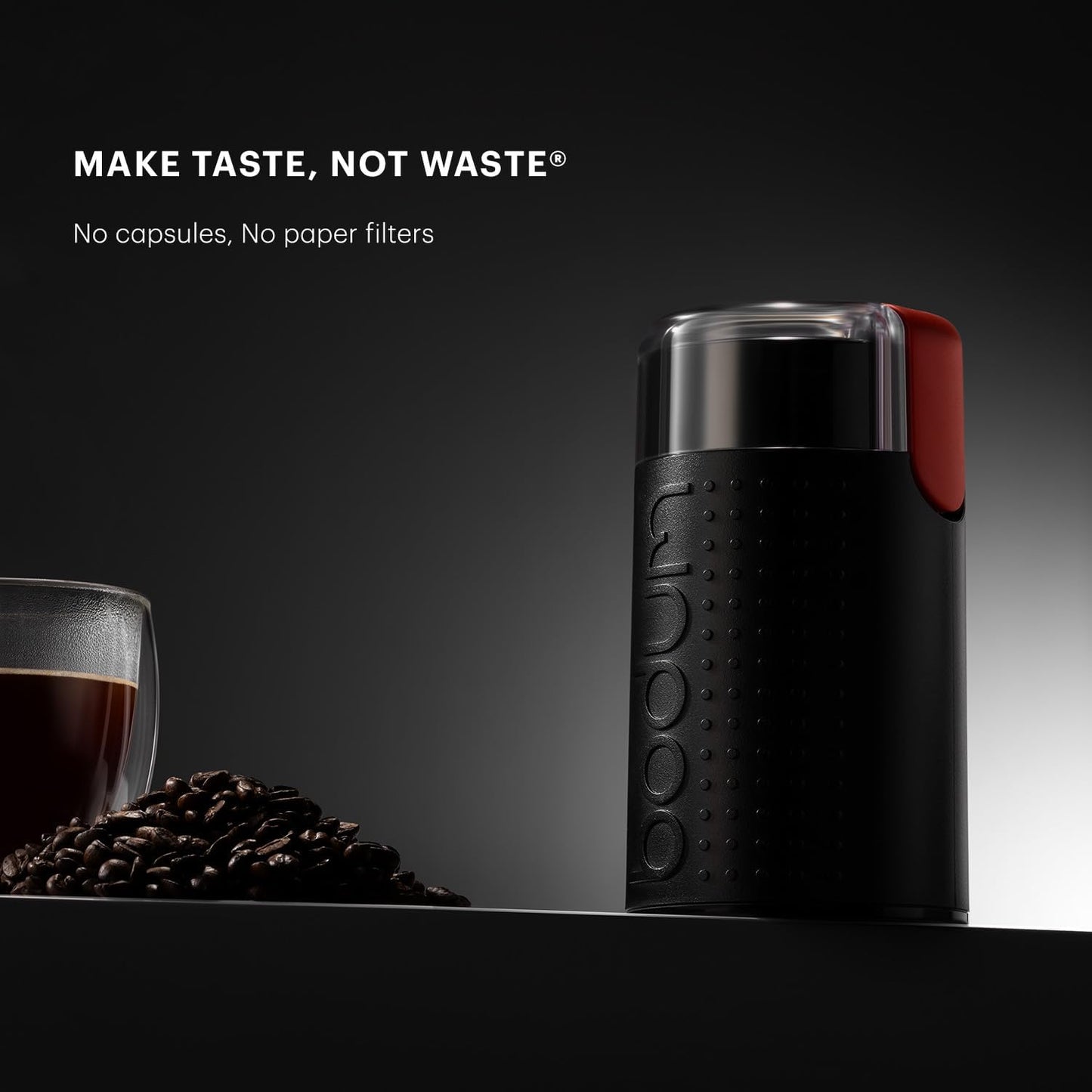 Black coffee grinder with a red accent on a dark surface with coffee beans and a cup of coffee, featuring the brand 'DOOMO'.