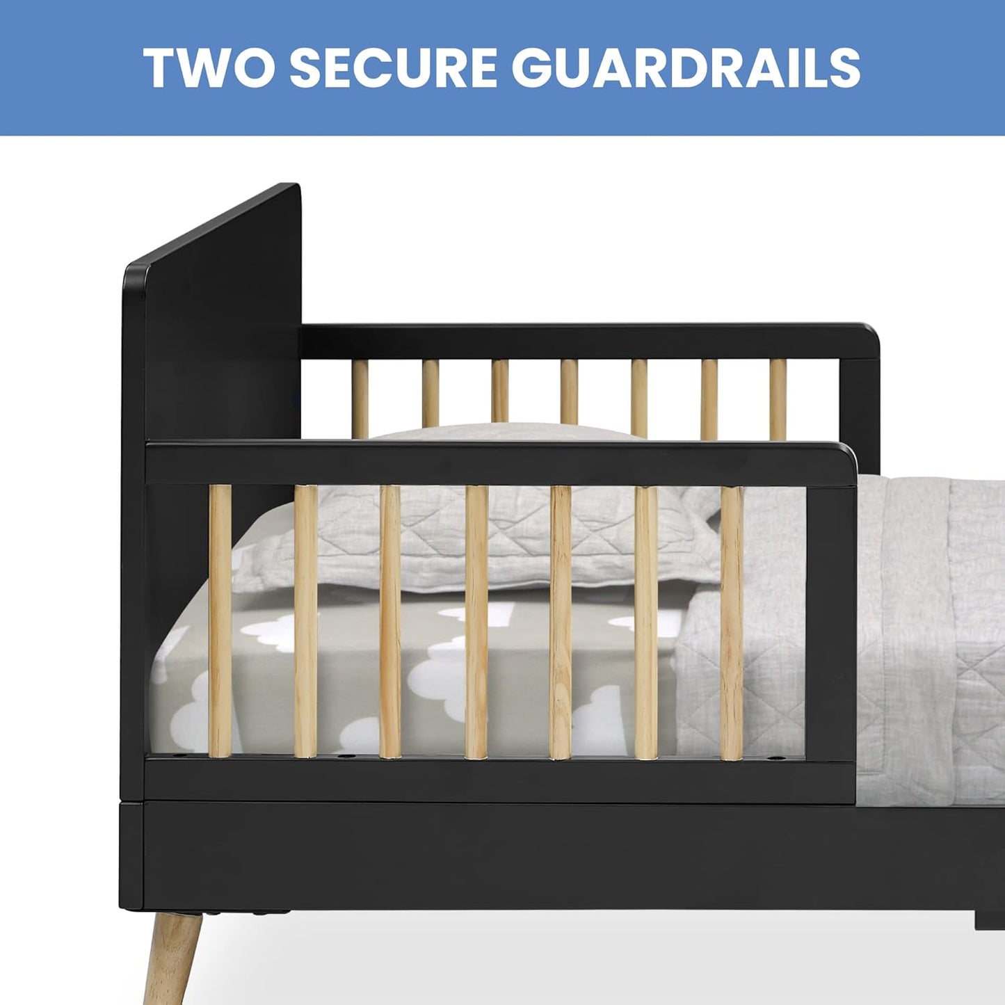 Black crib with wooden guardrails and a mattress on a white background