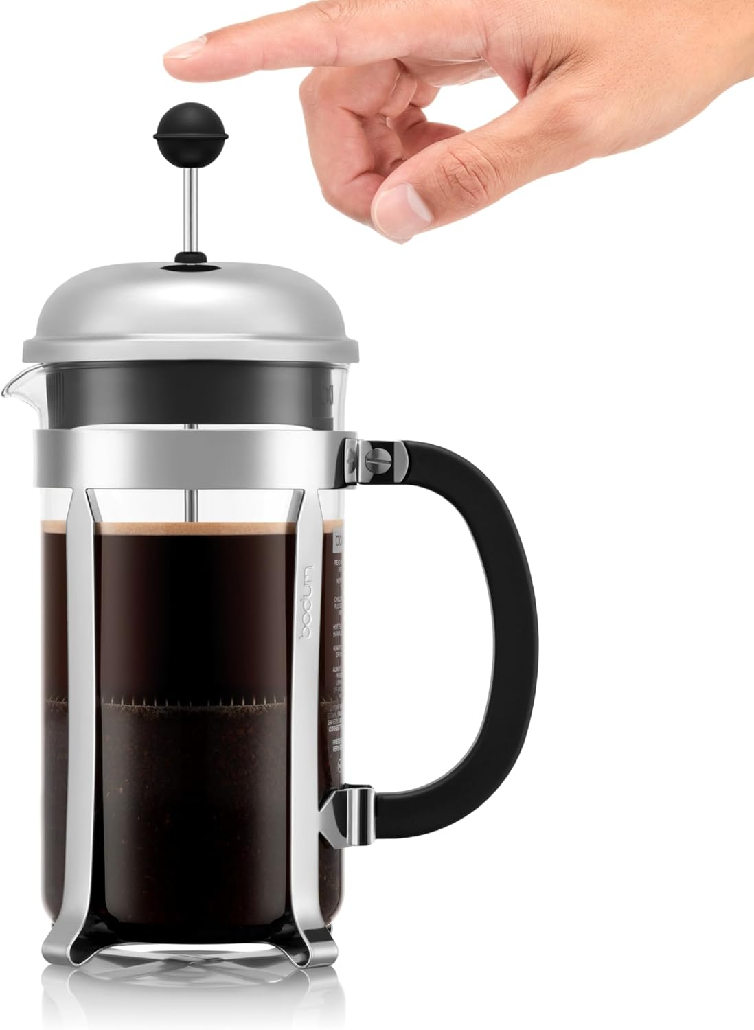 French press with coffee being pressed, hand holding plunger