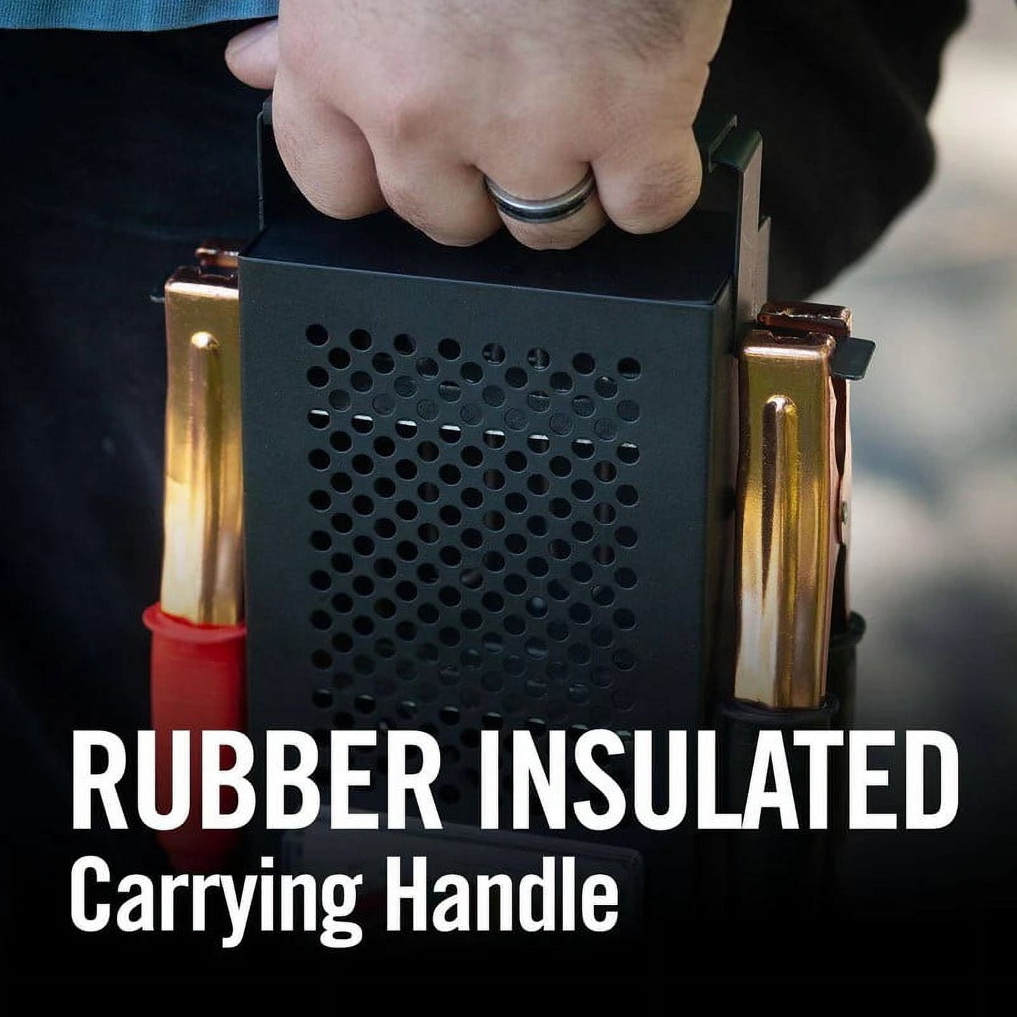 Black metal box with rubber insulated carrying handle held by a hand.