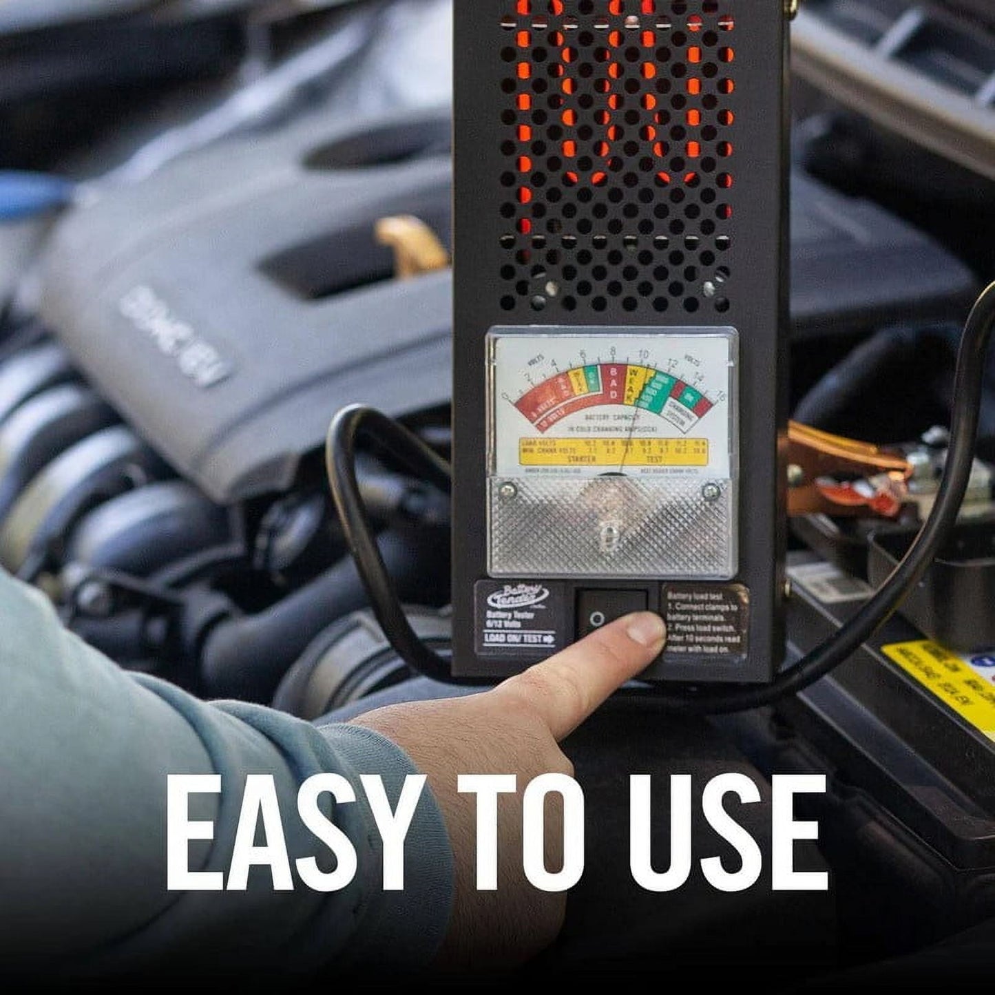 Person using a car battery tester with text 'EASY TO USE' on a blurred car engine background