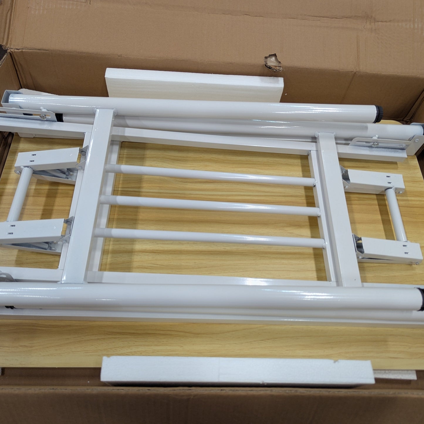 White metal frame assembly inside a cardboard box