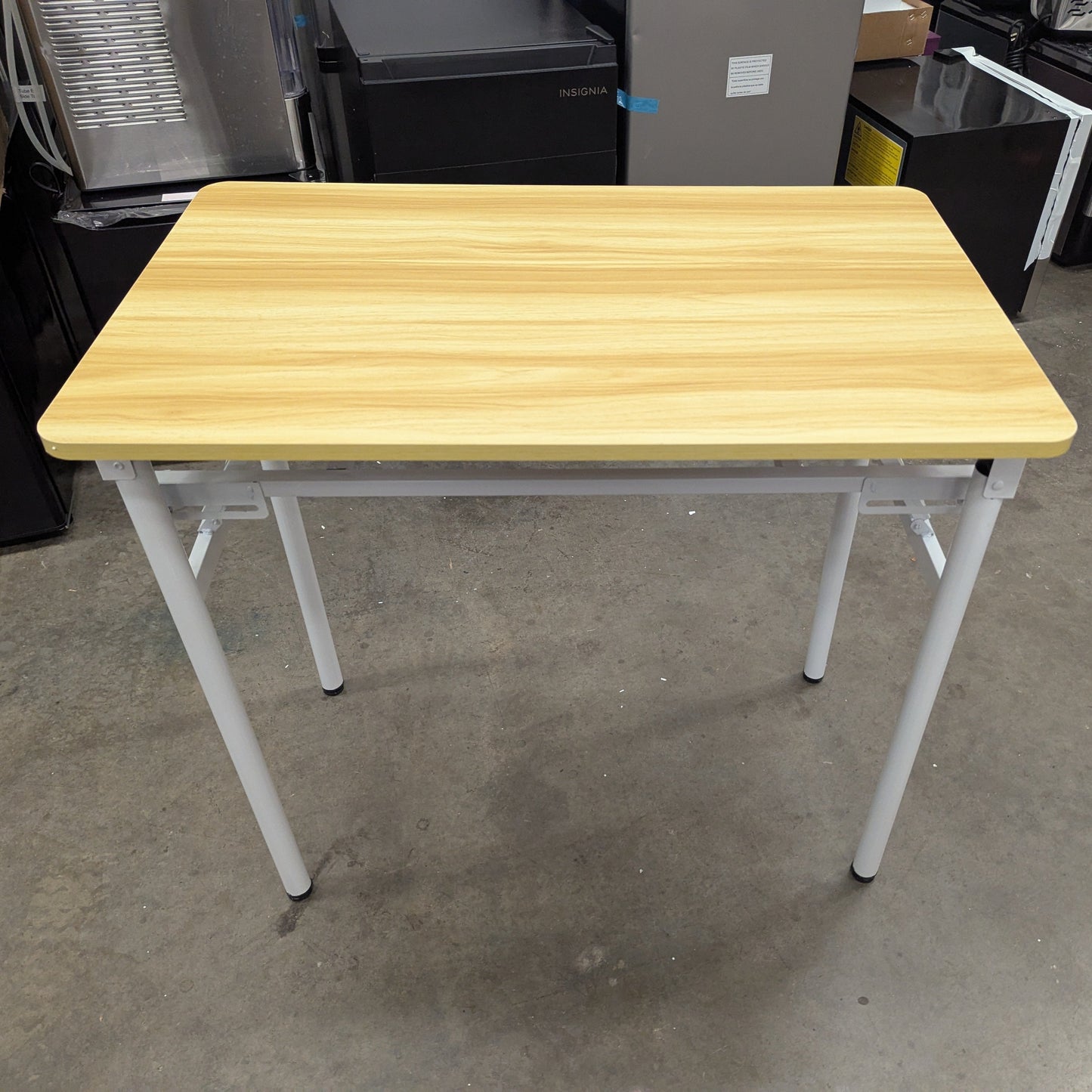 Wooden table with white legs in a warehouse setting