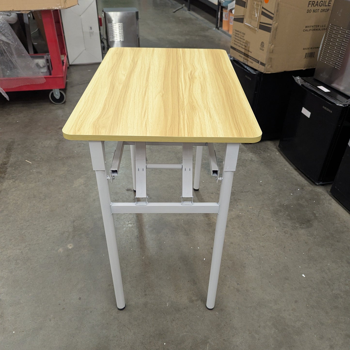 Wooden table with white legs in a warehouse setting