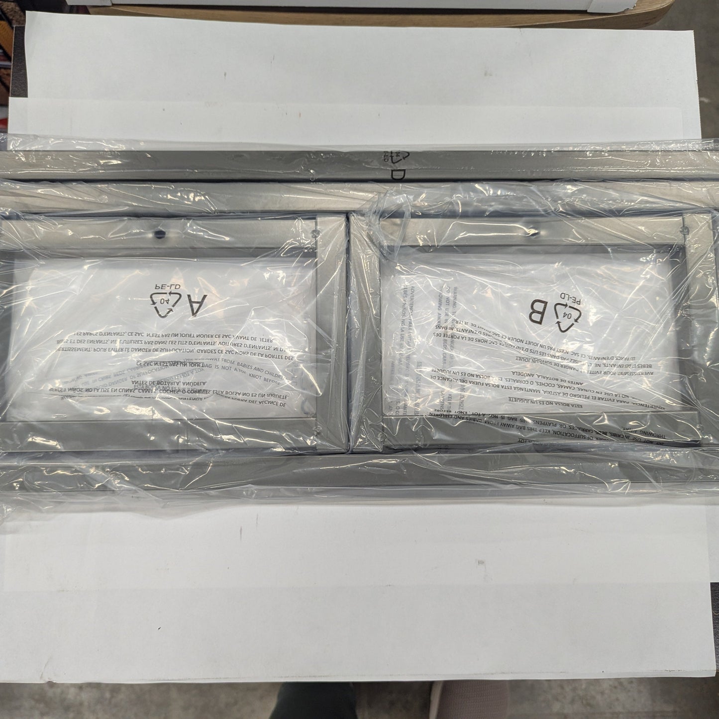 Two metallic frames with labels on a white surface