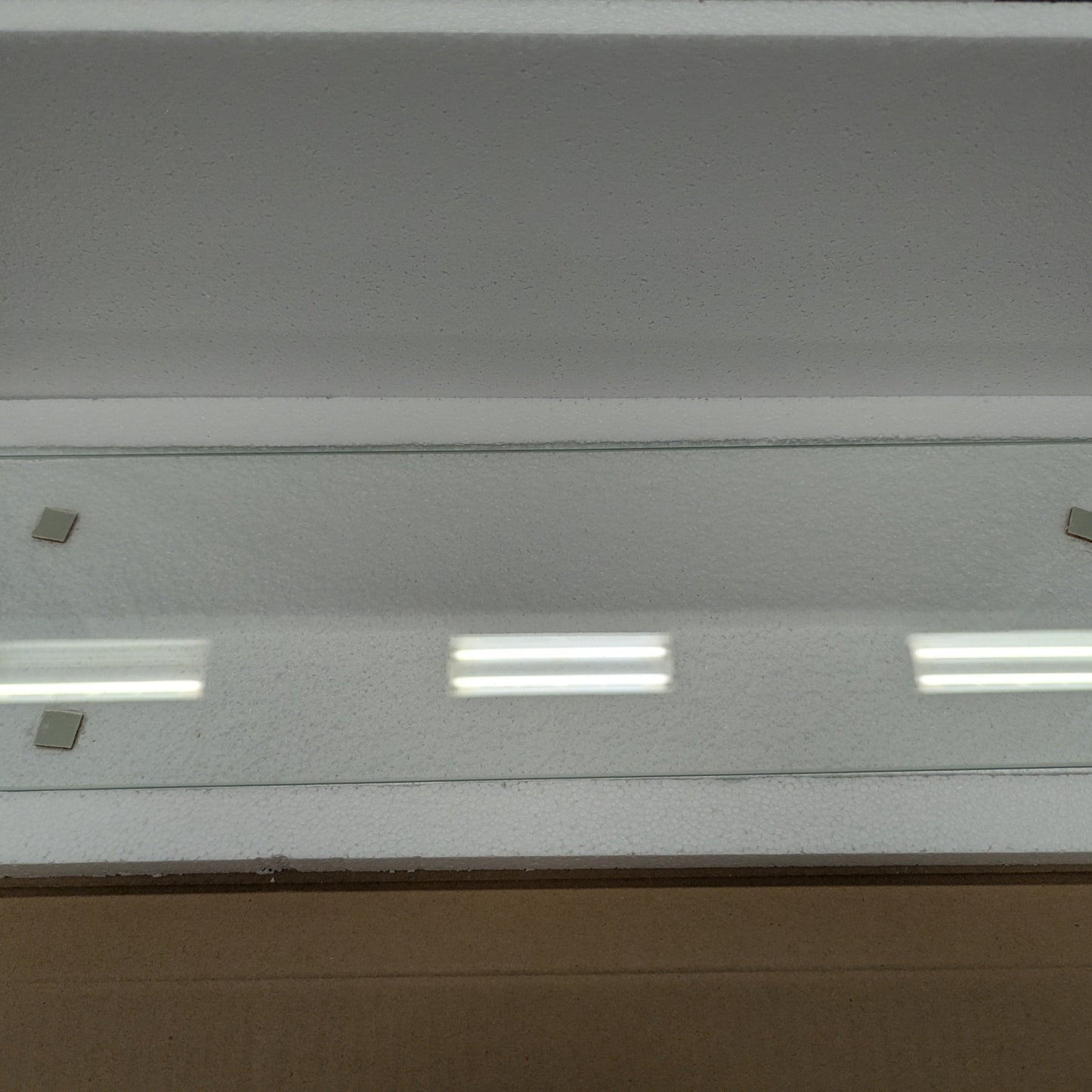 Glass panel with embedded lights in a cardboard box