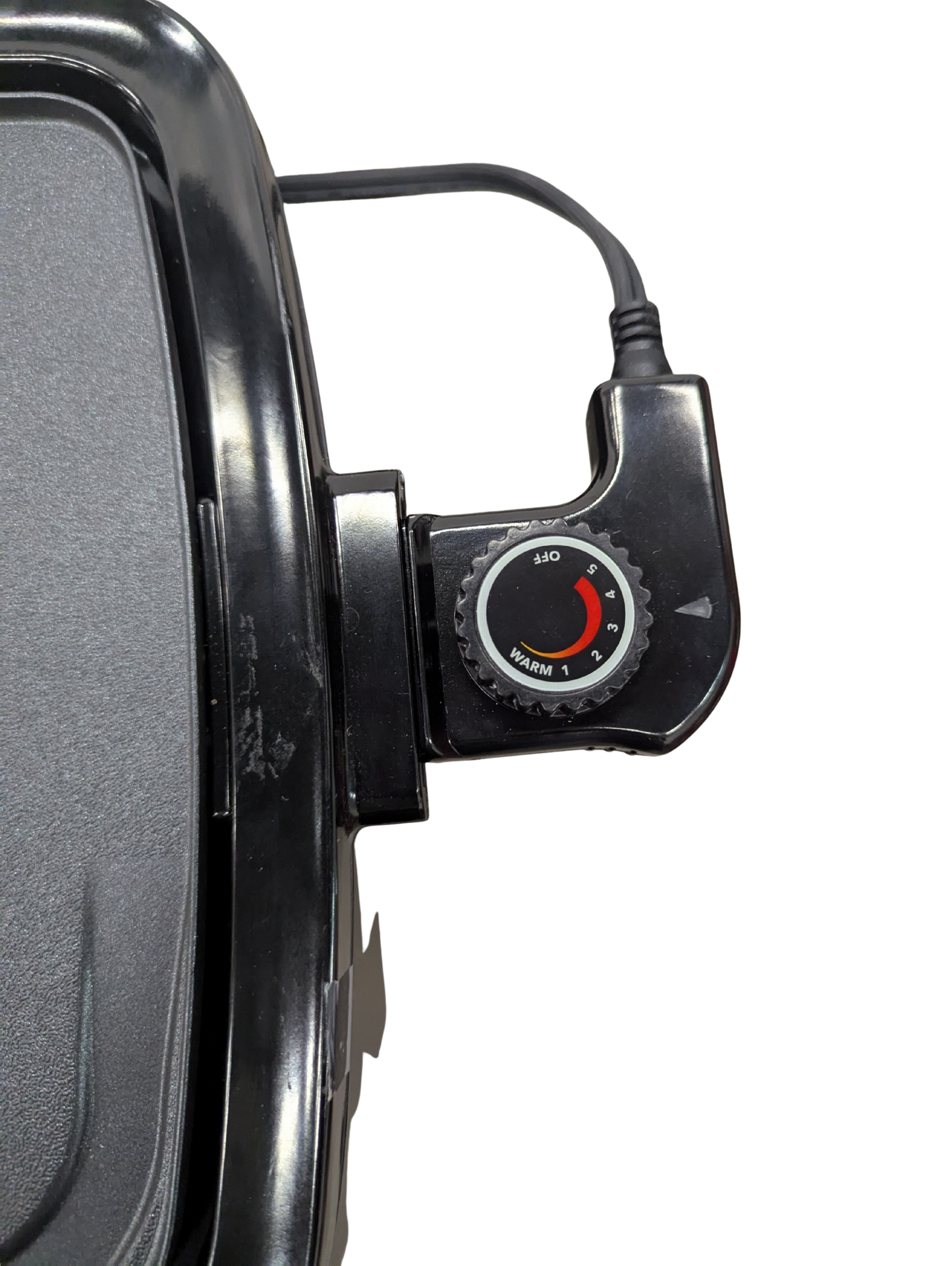 Close-up of a black electronic device with a dial on a white background