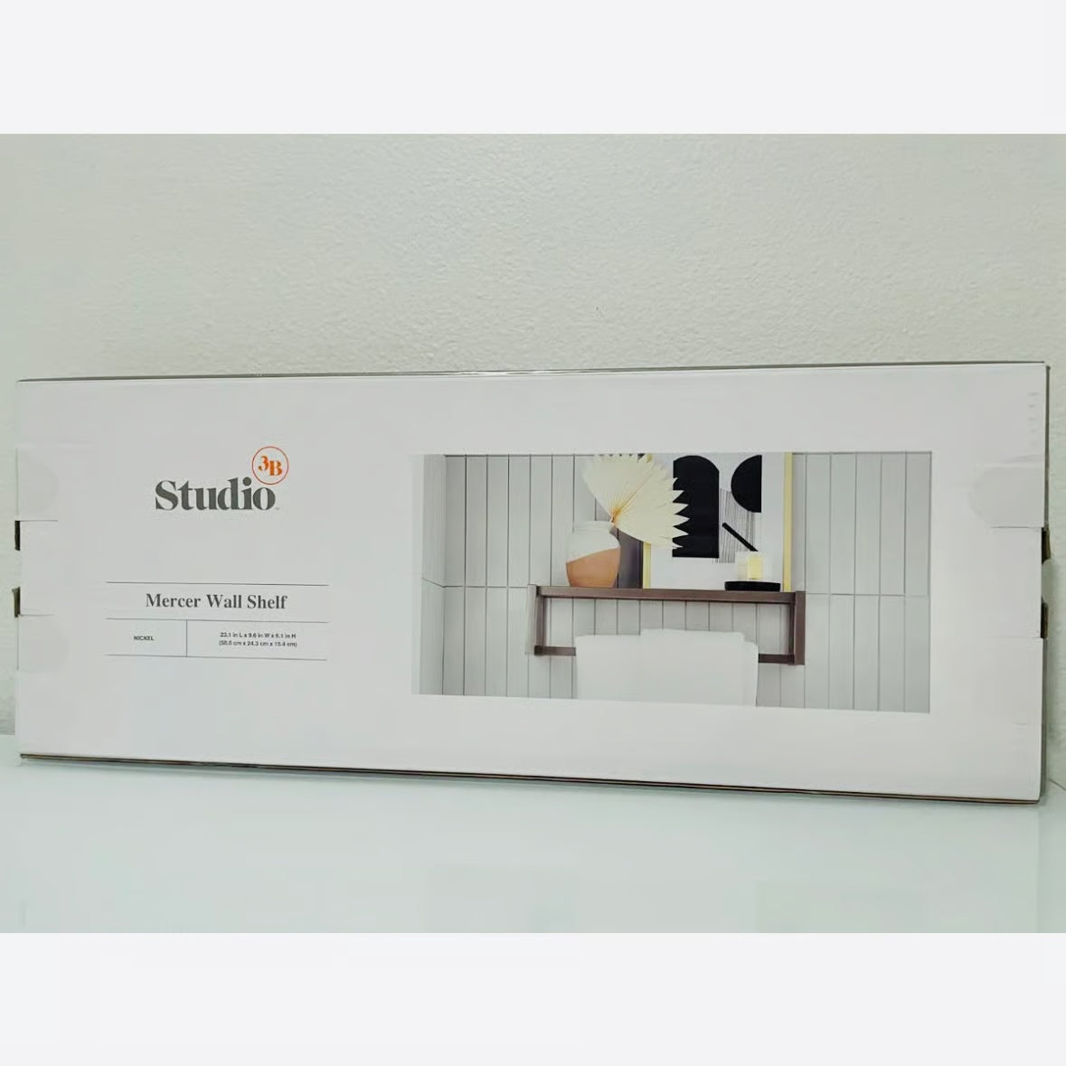 Box packaging of a Mercer Wall Shelf with a product image on a white background