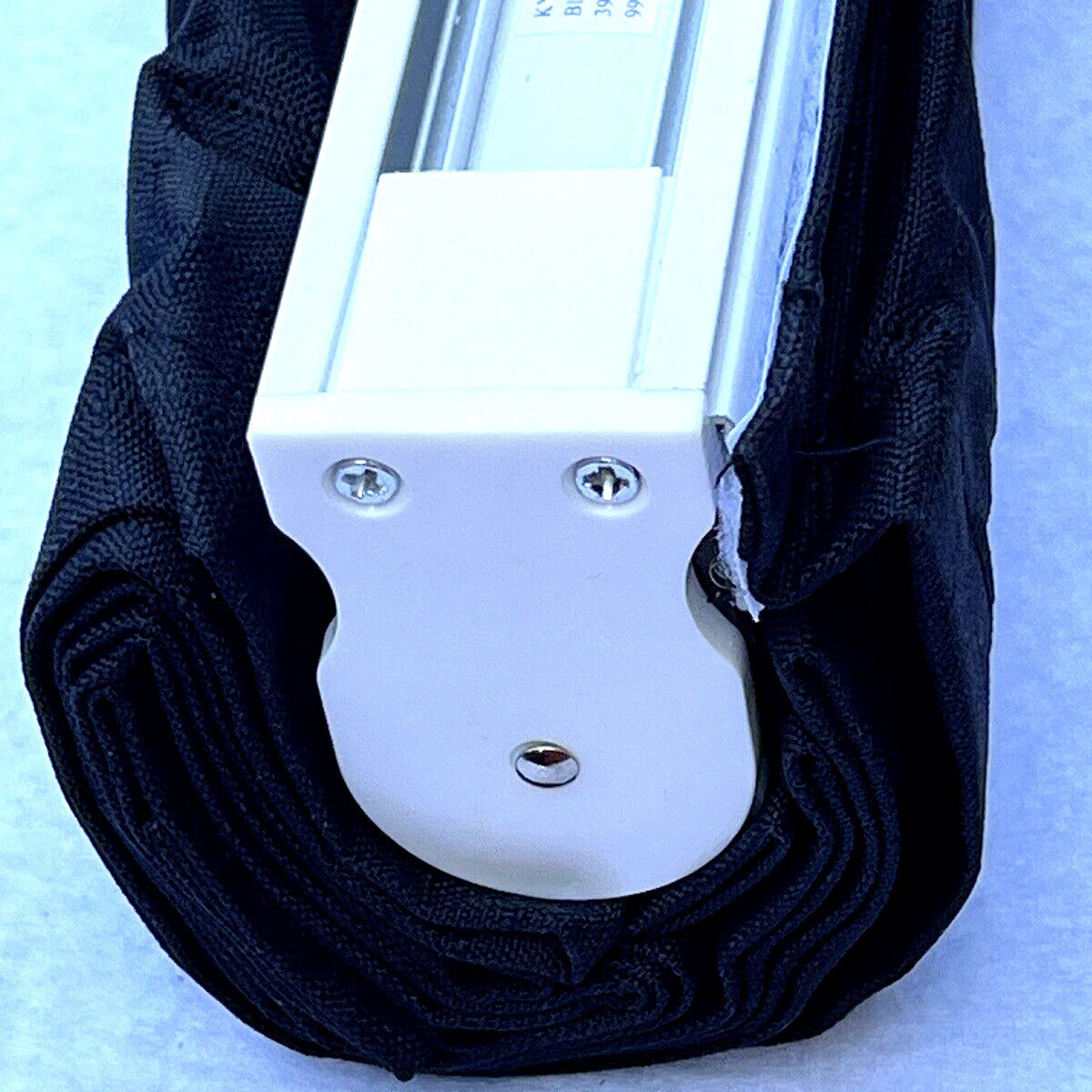 Close-up of a black strap with a white metal buckle on a light blue background