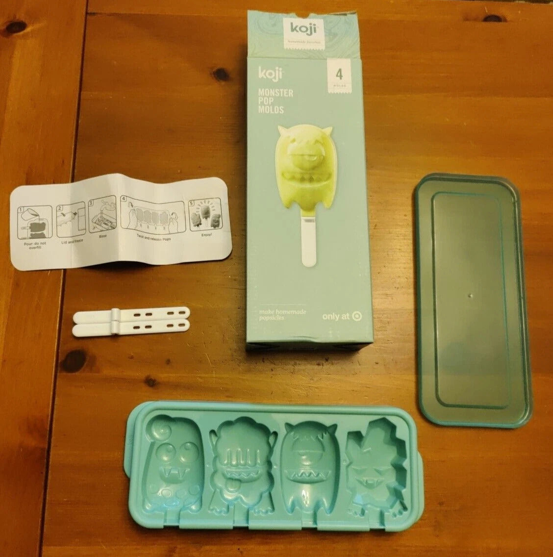 Kaji ice pop mold set with packaging, instructions, and accessories on a wooden surface