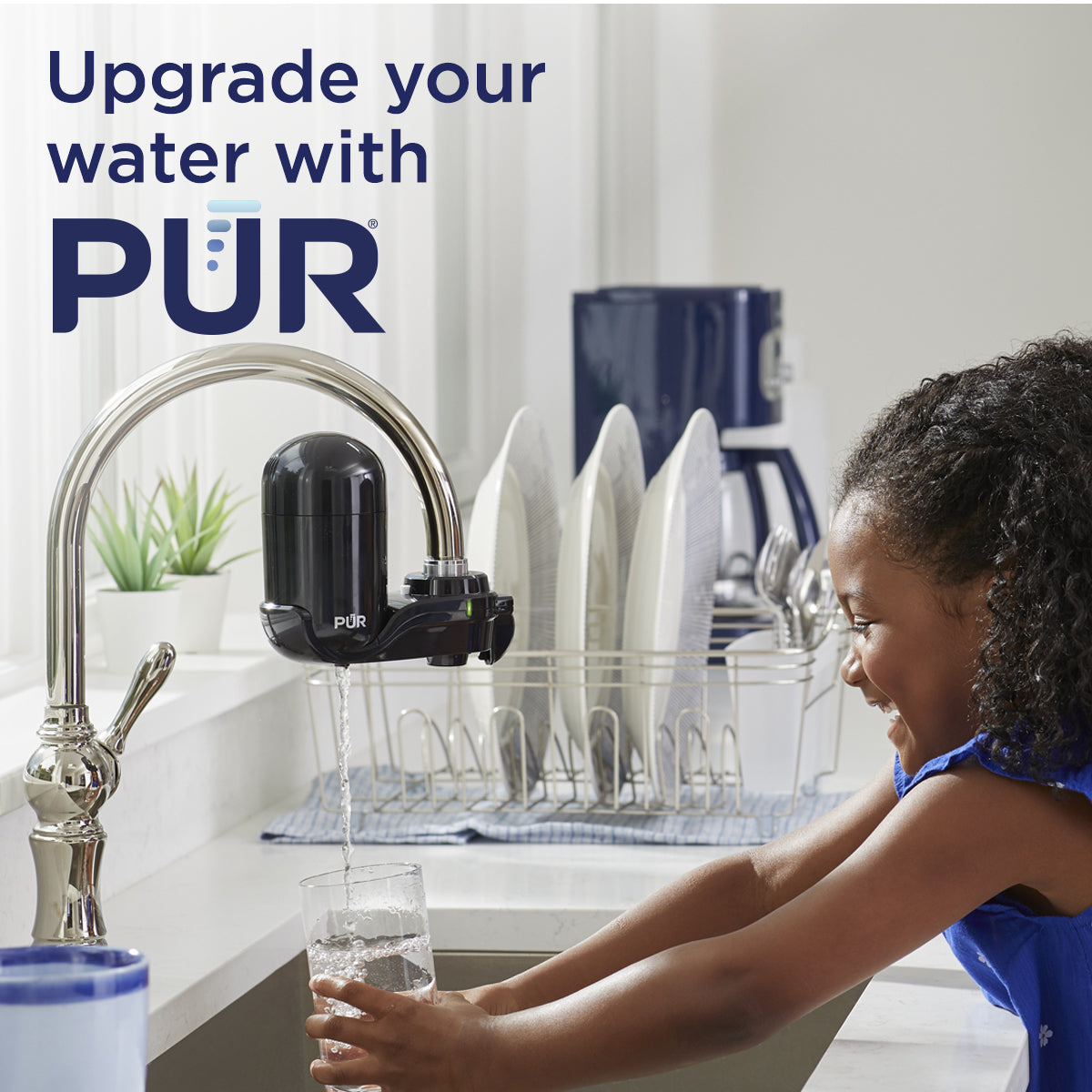 Child washing hands under a PUR water faucet in a kitchen.