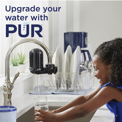 Child washing hands under a PUR water faucet in a kitchen.