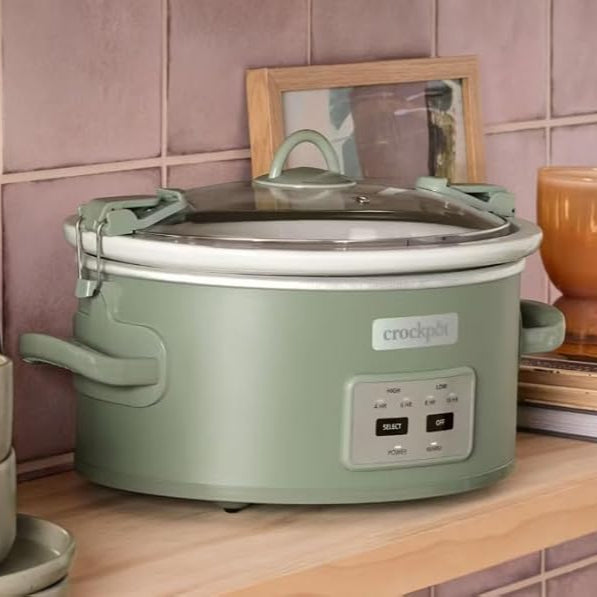 Green Crock-Pot on a kitchen counter with a pink tiled wall in the background