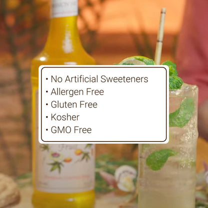 Bottle of a beverage with a glass of a green drink and a straw, set against a blurred background.