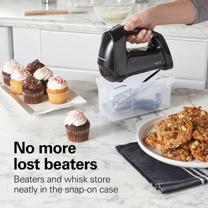Hand mixer with snap-on case on a kitchen counter with baked goods.