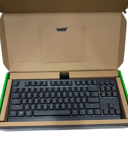 Black keyboard inside an open cardboard box on a white background