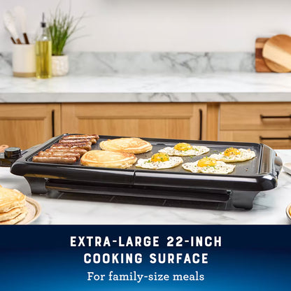 Electric griddle with food on a kitchen counter, text indicating large cooking surface.