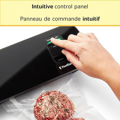 Hand operating an intuitive control panel on a FoodSaver device with a vacuum-sealed meat patty in the foreground.