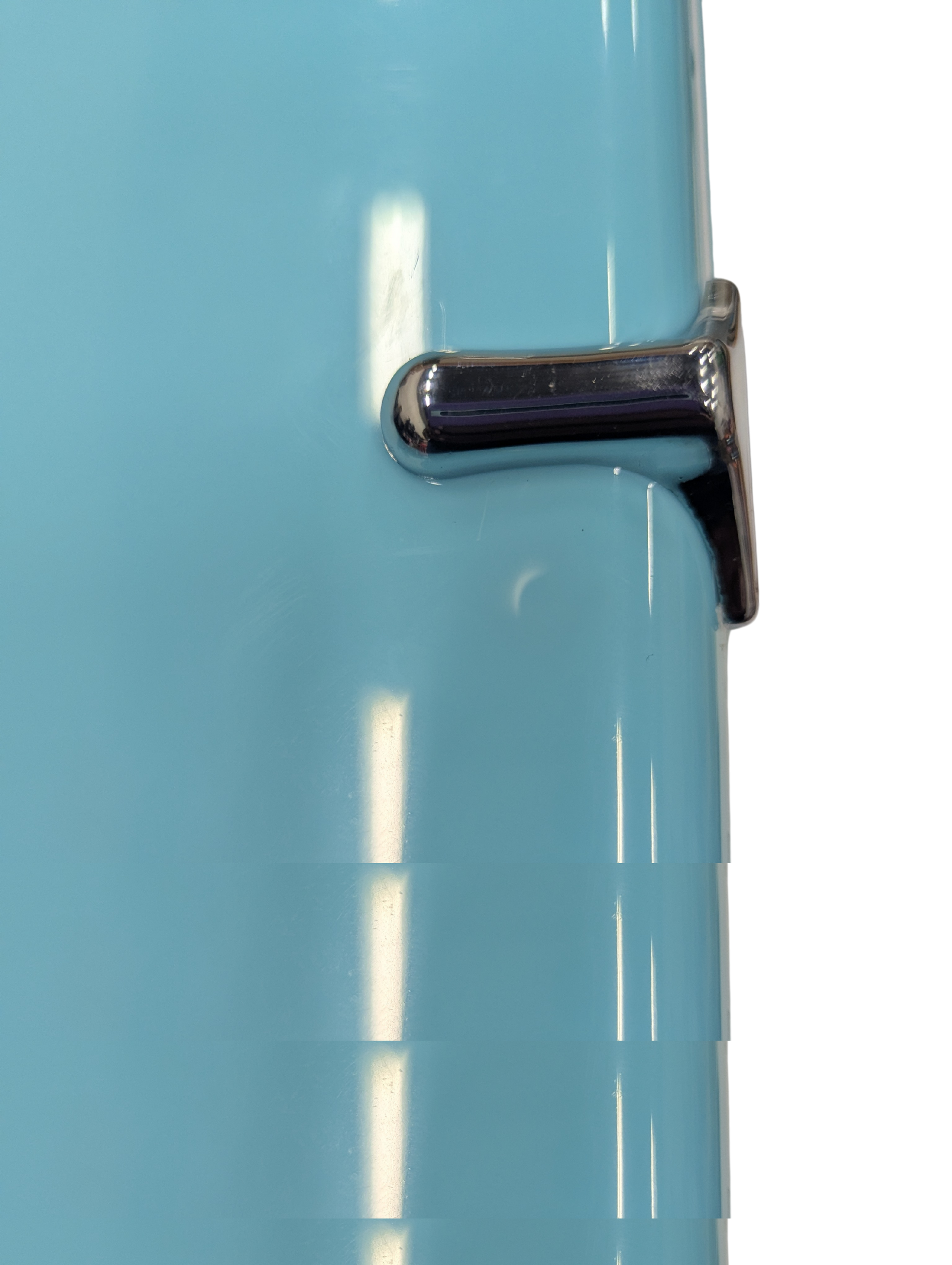 Close-up of a blue refrigerator with a chrome handle on a white background