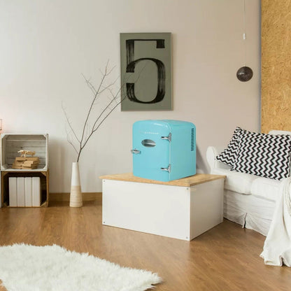Turquoise mini refrigerator on a wooden table in a living room setting.