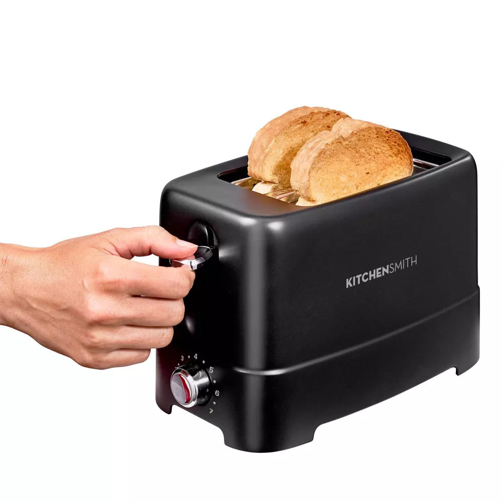 Black toaster with bread slices being inserted, brand 'KitchenSmith' visible