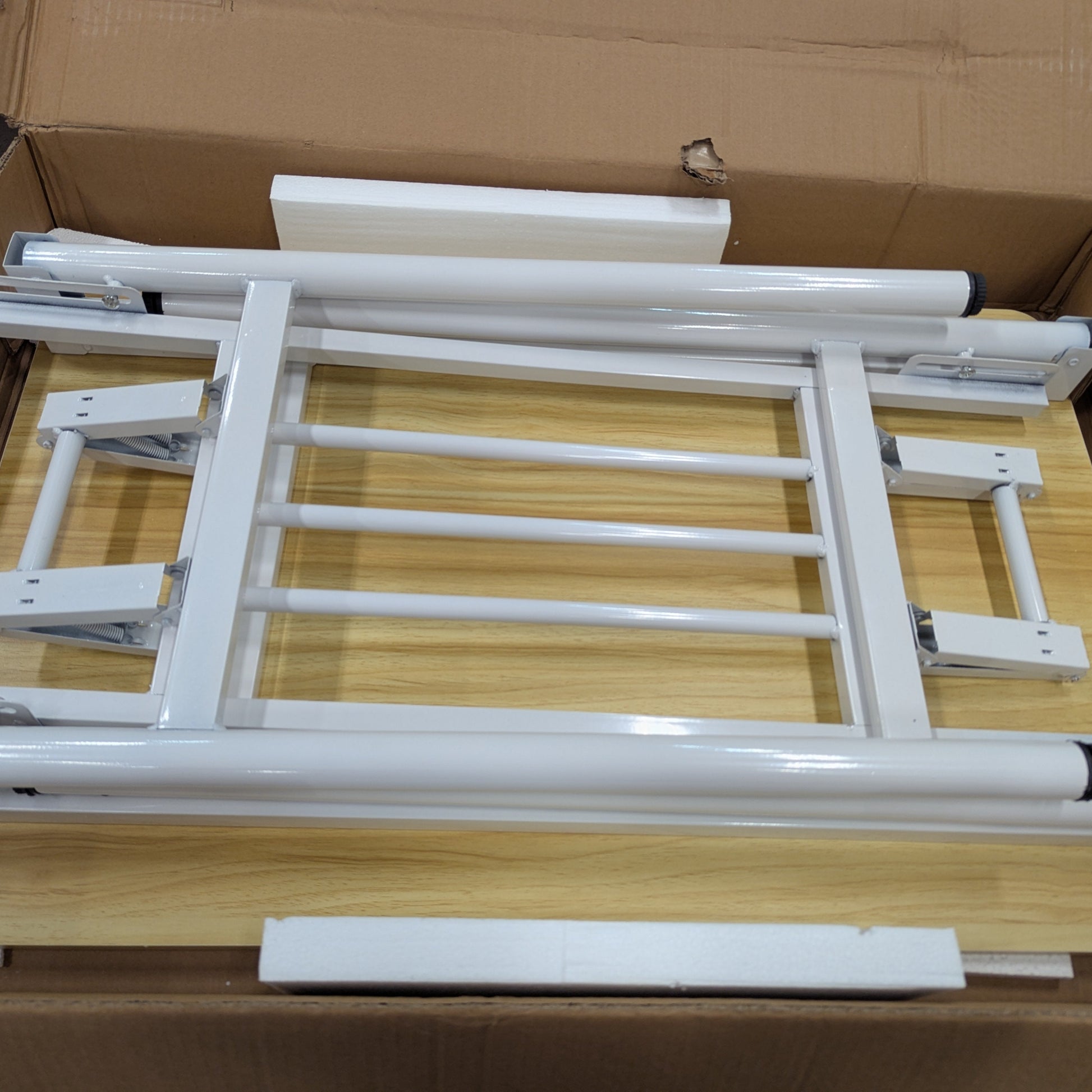 White metal frame assembly inside a cardboard box