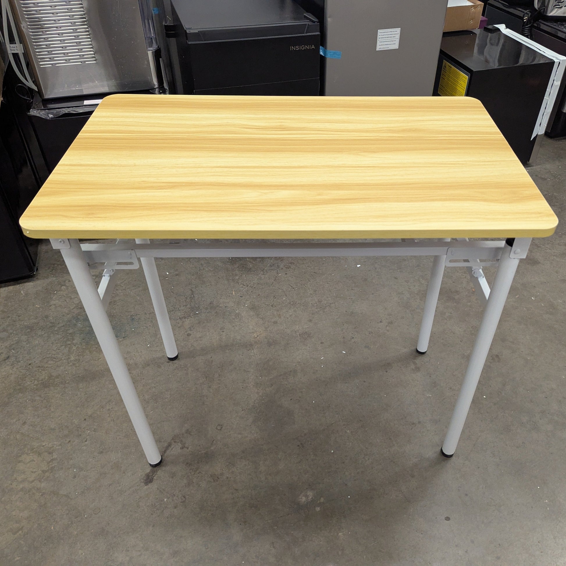 Wooden table with white legs in a warehouse setting