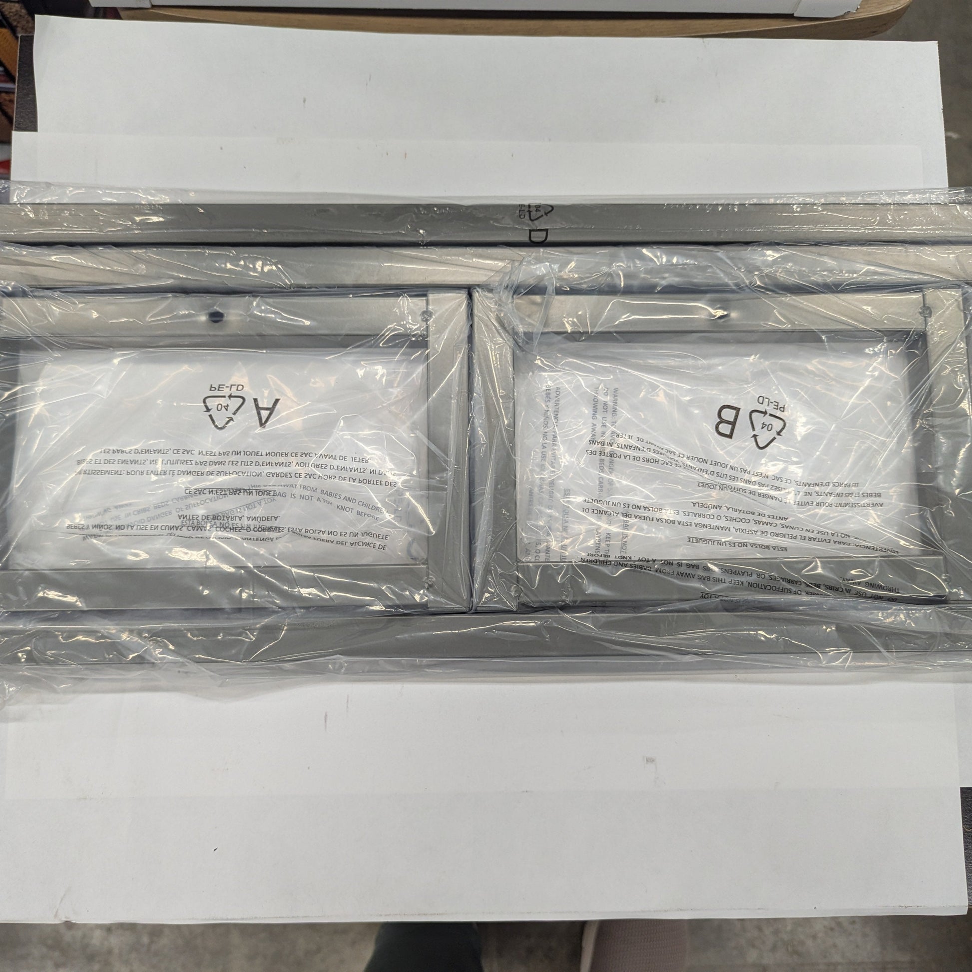 Two metallic frames with labels on a white surface