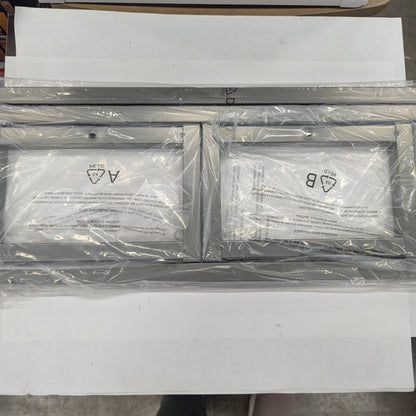 Two metallic frames with labels on a white surface