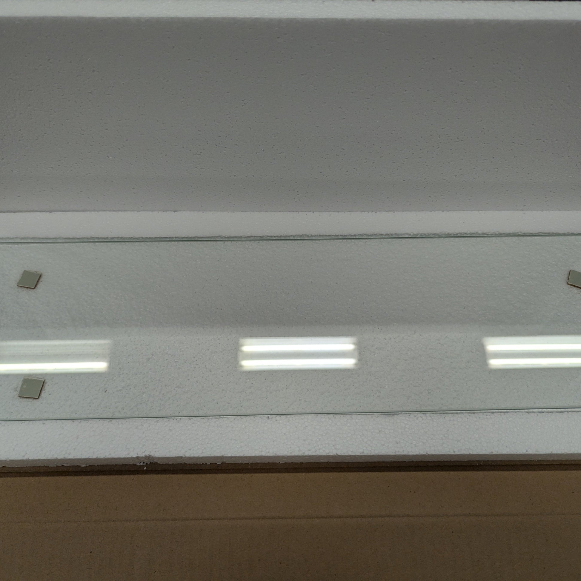 Glass panel with embedded lights in a cardboard box
