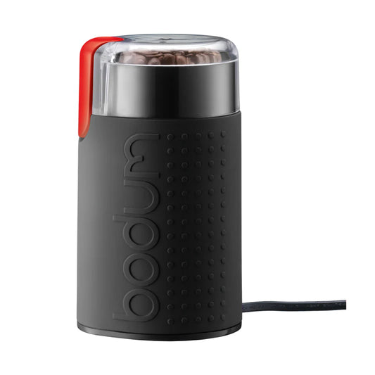 Black coffee grinder with red top on a white background