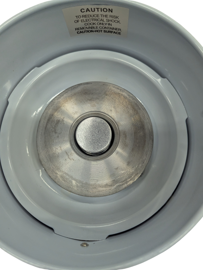 Close-up of a metal stove burner with a warning label on a white background