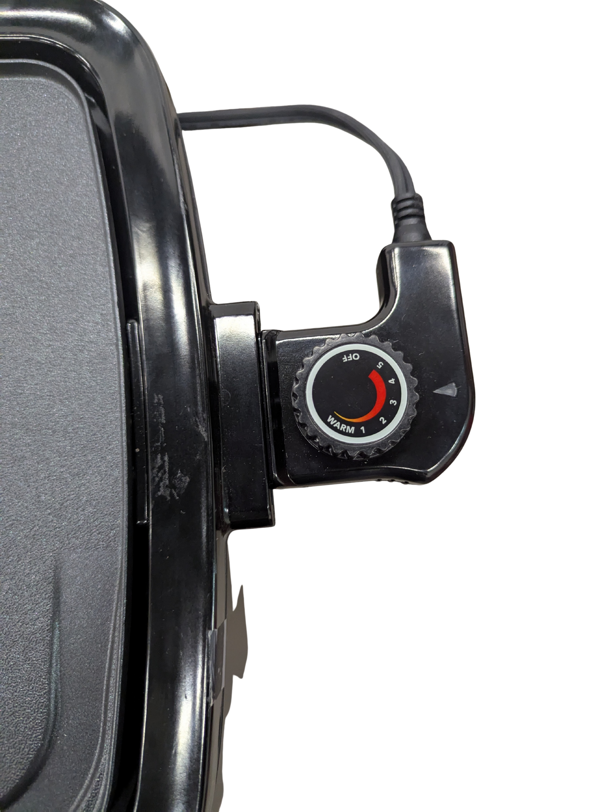 Close-up of a black electronic device with a dial on a white background