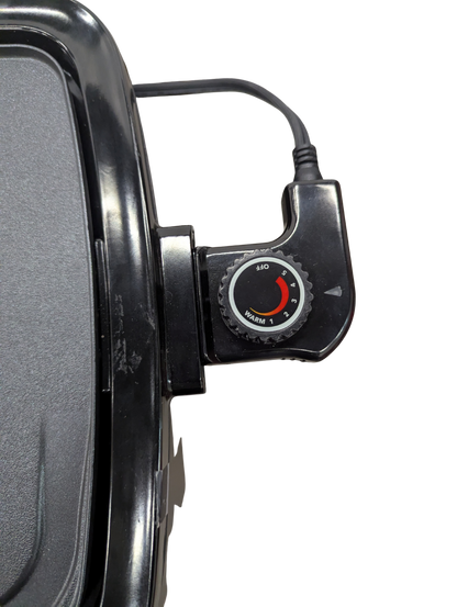 Close-up of a black electronic device with a dial on a white background
