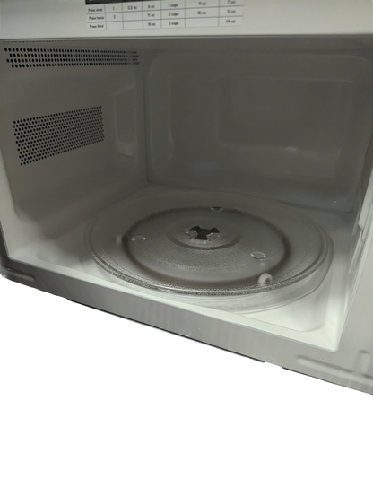 Empty microwave interior with turntable on a white background