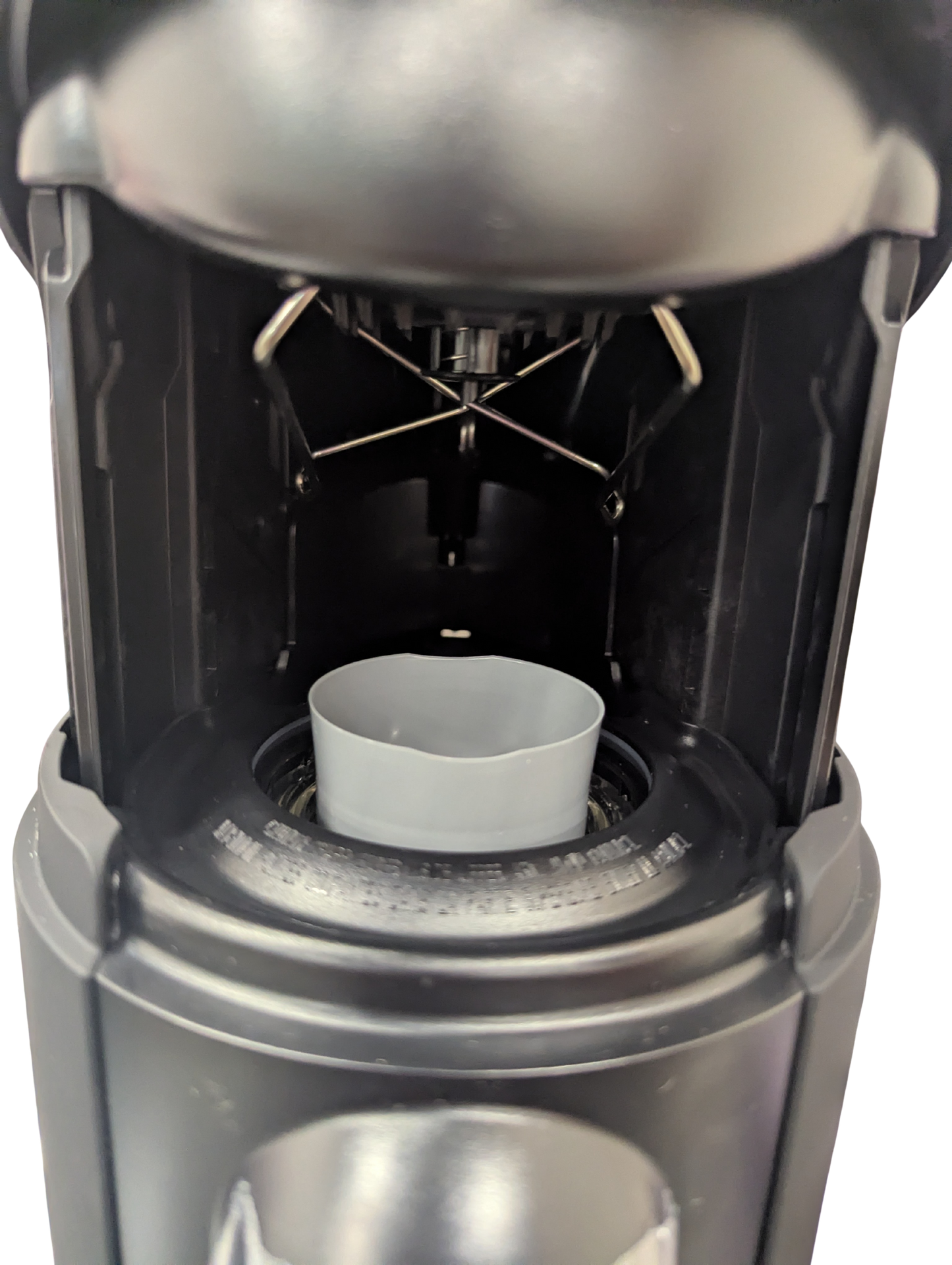 Close-up of a coffee brewing device with a white filter basket.