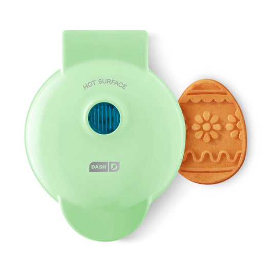 Green cookie press with a floral design on a white background