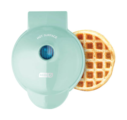 Mint green waffle maker with a cooked waffle on a white background