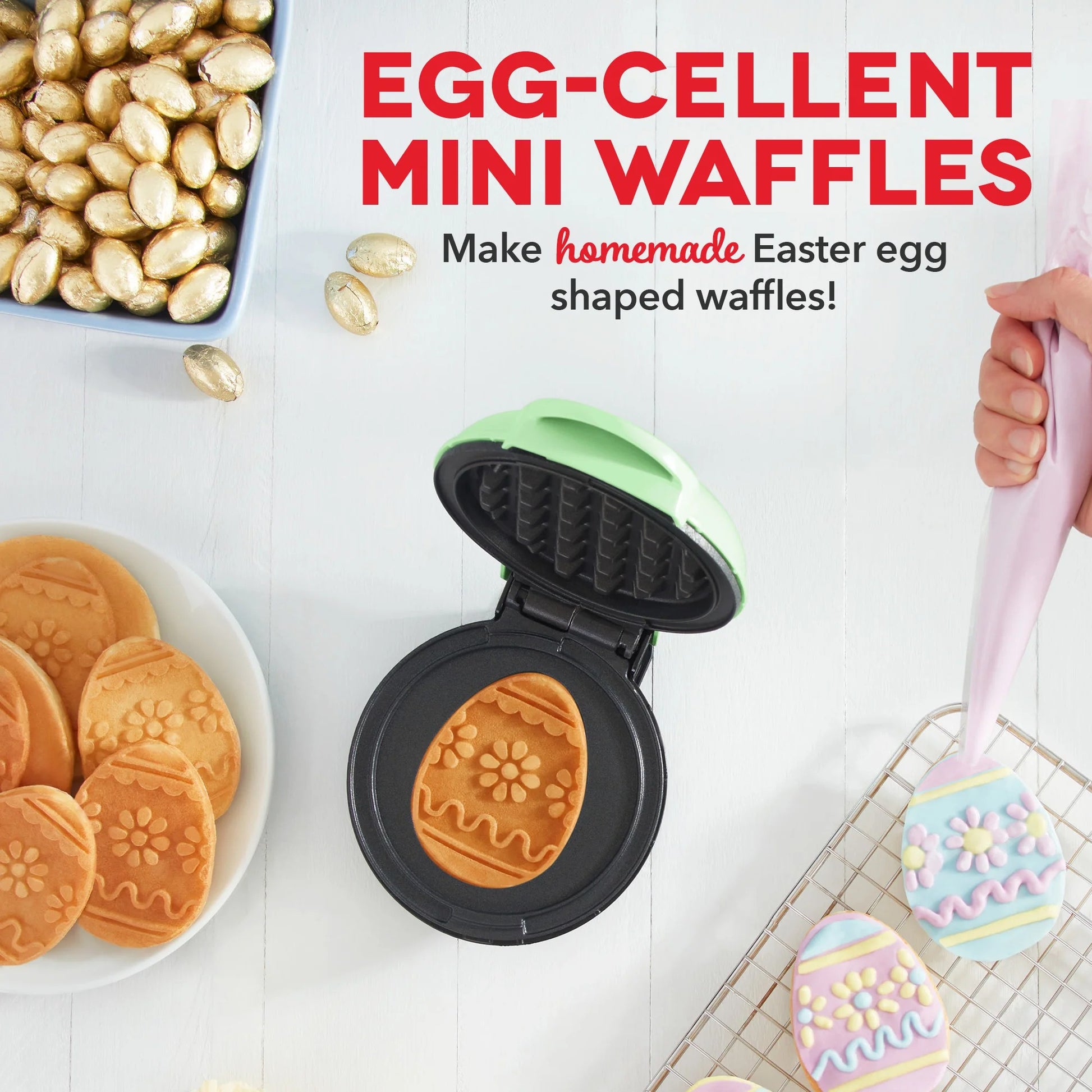 Egg-shaped waffle maker with Easter-themed waffles on a white background